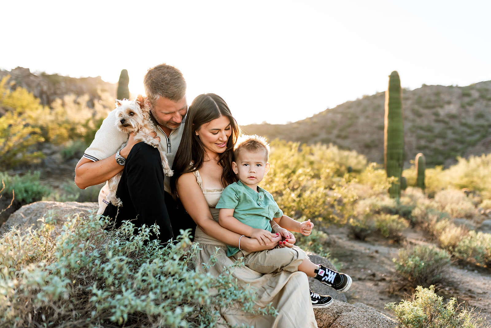 Family of three sit on rocks during Rose Garden Mountain Family photo session