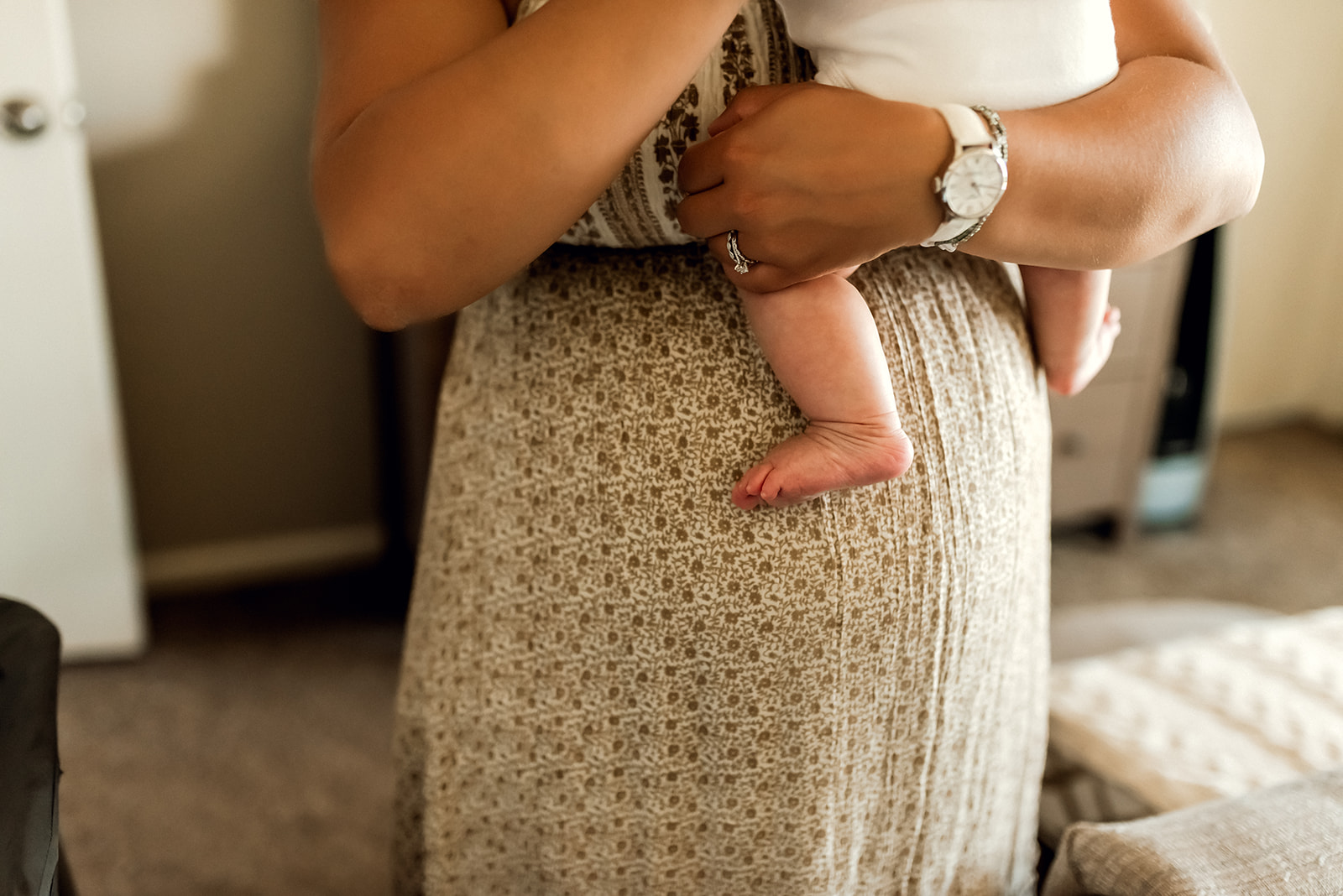 Newborn photograph of mother holding her baby with the focus on the baby's foot.