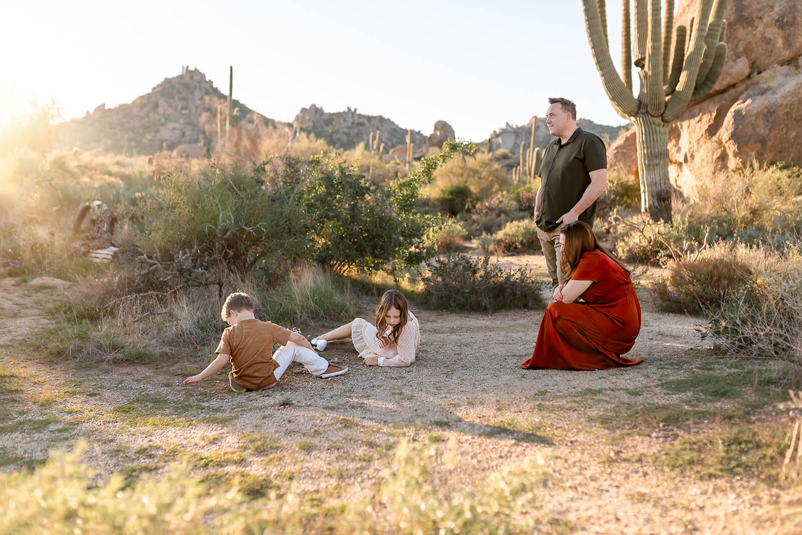 Kids explore the dirt while parents look on during a desert family photography photo session with Lindsay Jane Photography