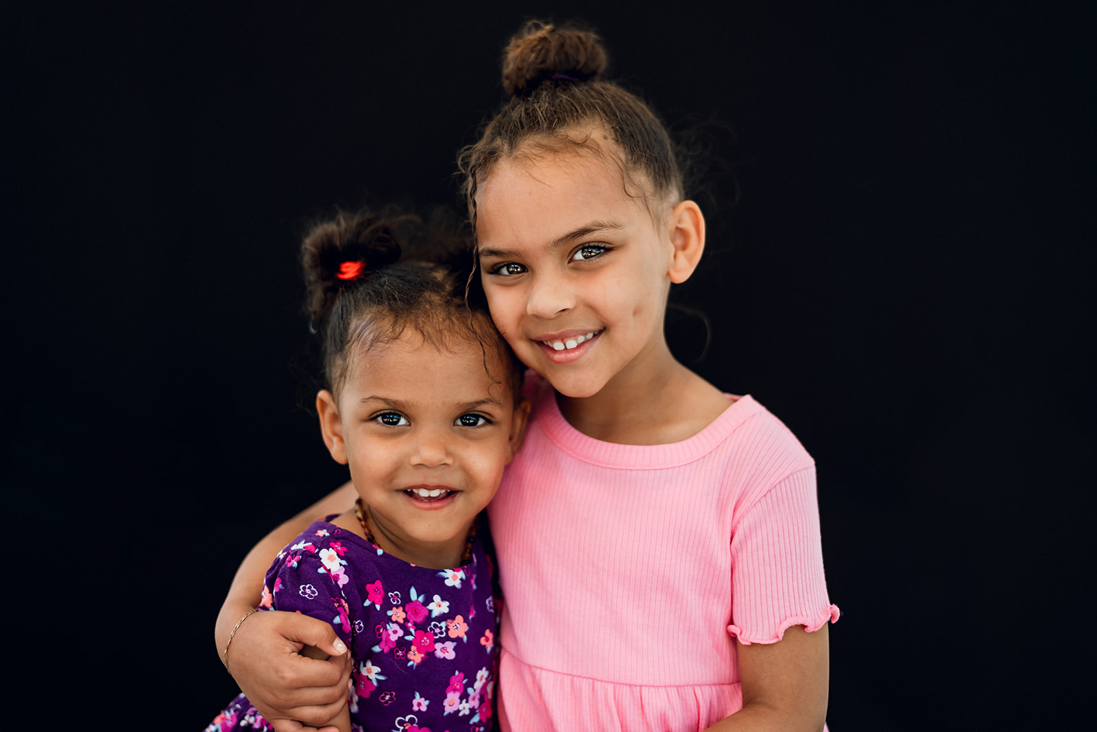 Siblings smile at the camera during a fine art school portrait
