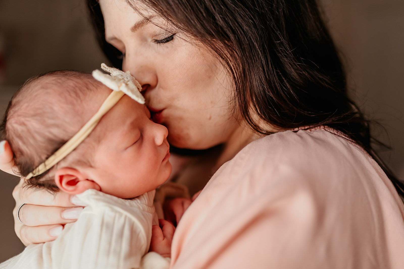 Mom gives newborn baby a kiss