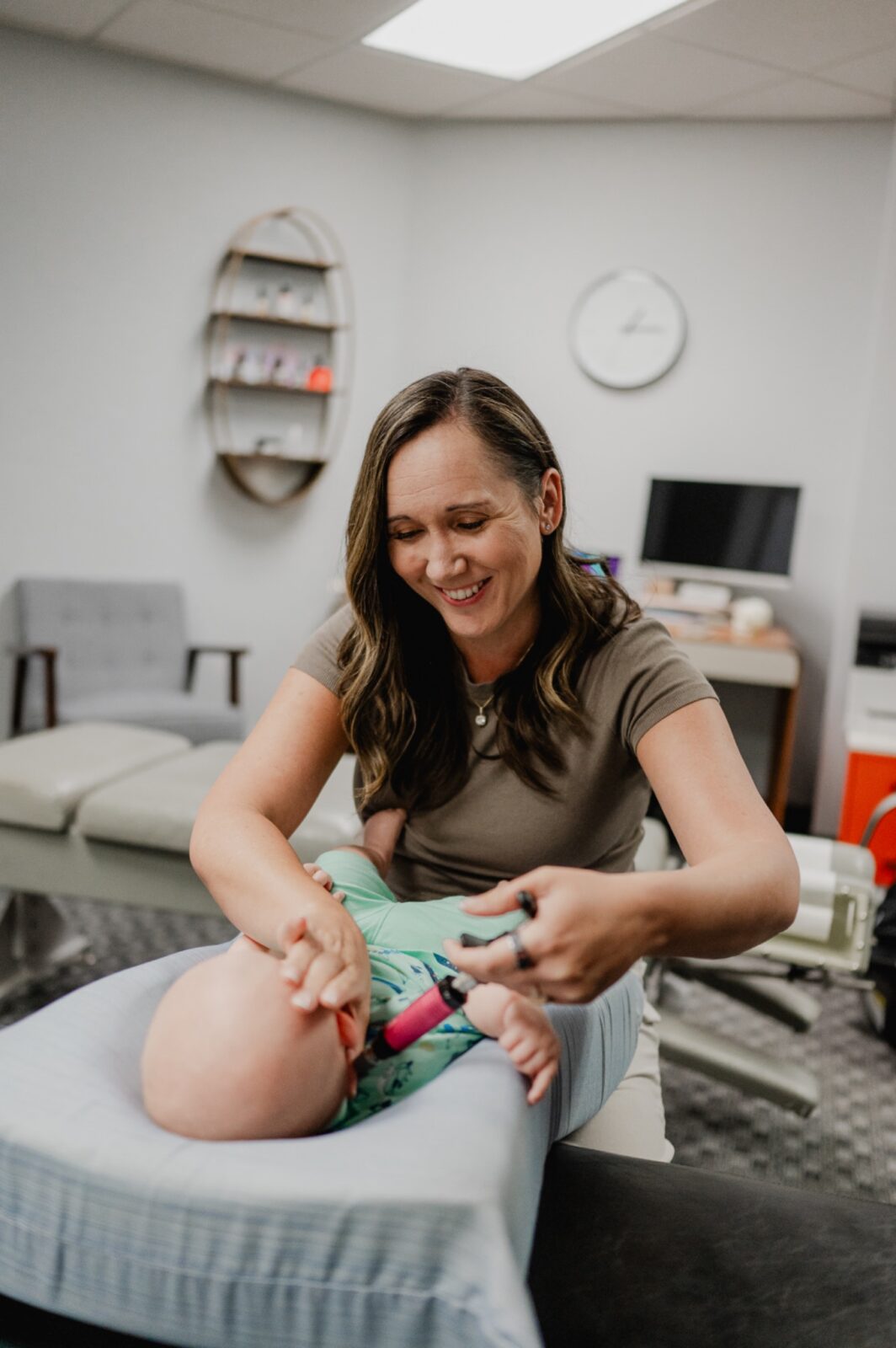 Dr. Ashley adjusts a baby during a chiropractor session in Phoenix.
