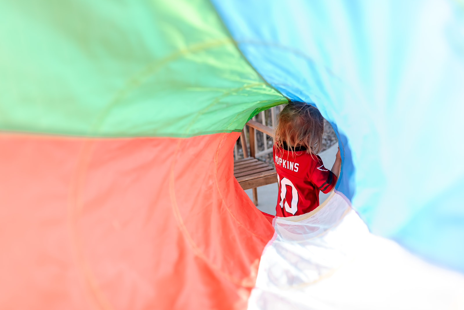 A tunnel of color frames a little girl wearing a sporting journey