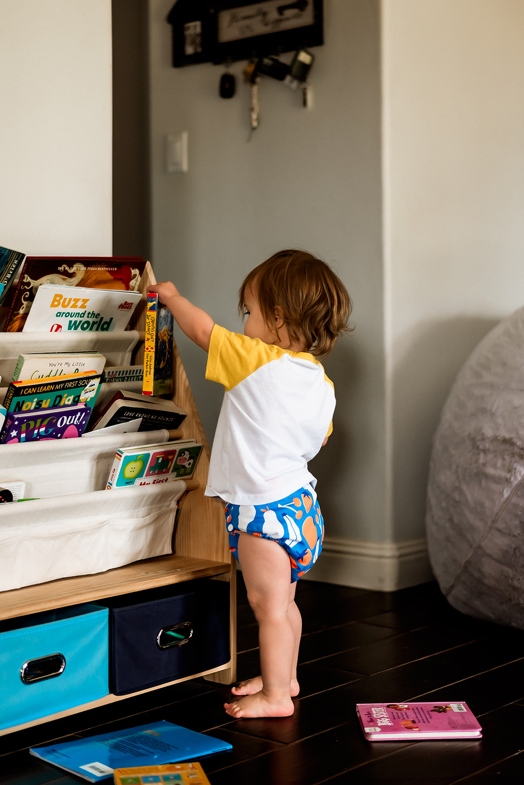 Little boy stands in a shirt in front of books