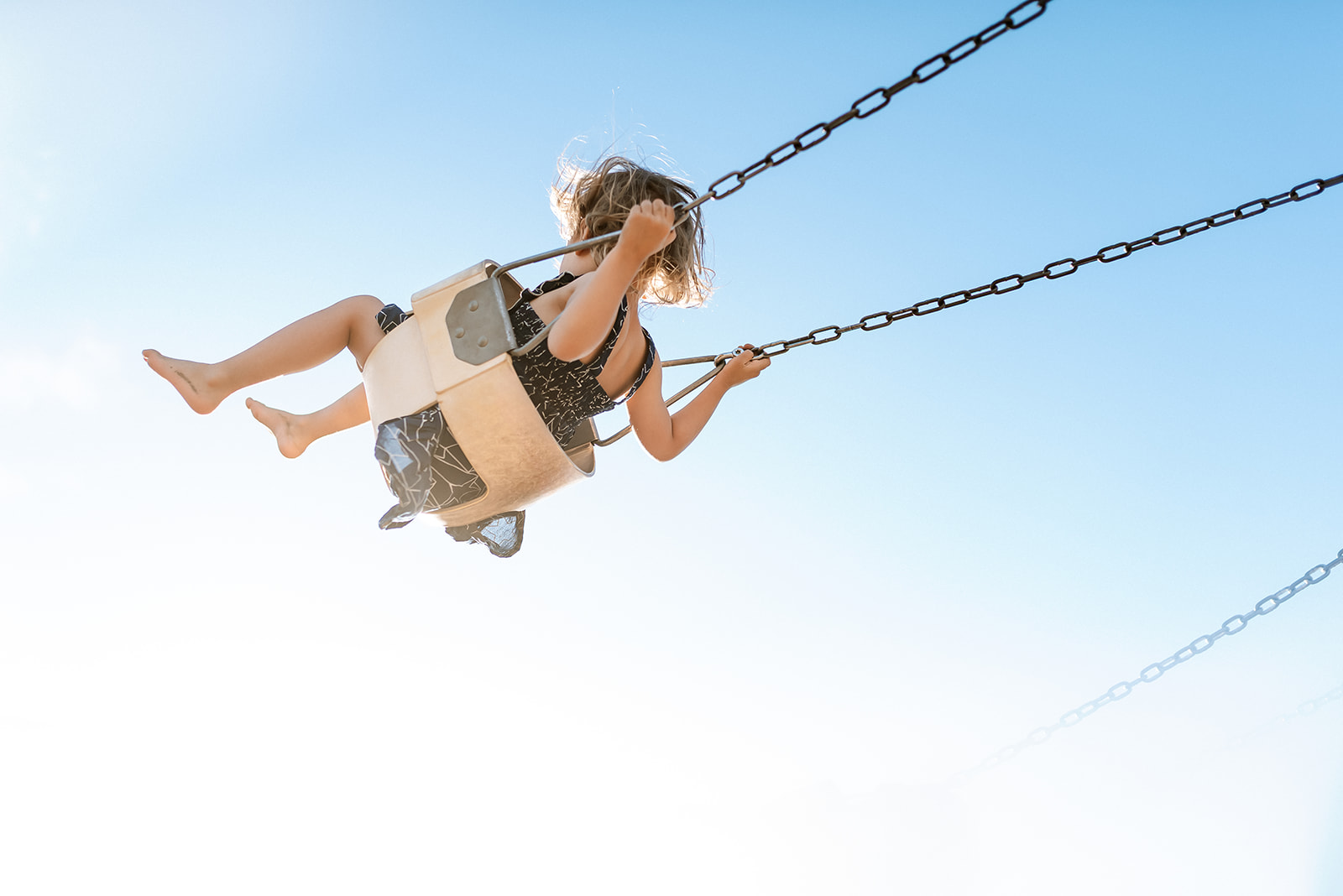 Little swings into the blue sky.